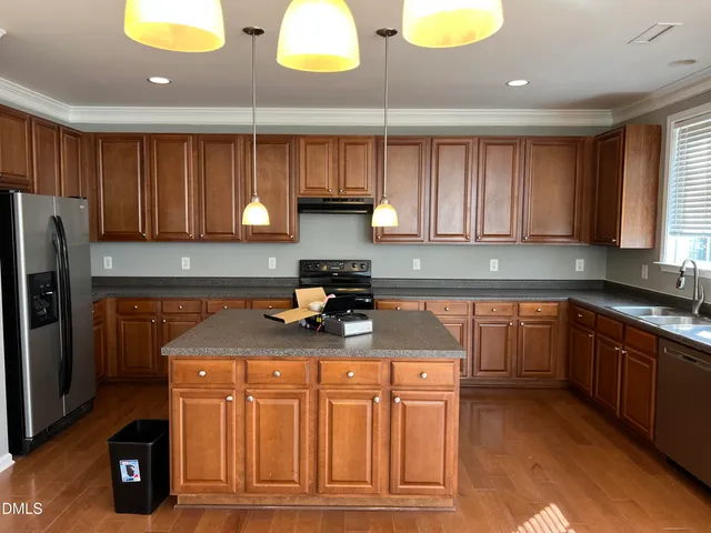 a kitchen with stainless steel appliances granite countertop a sink a stove cabinets and a counter space