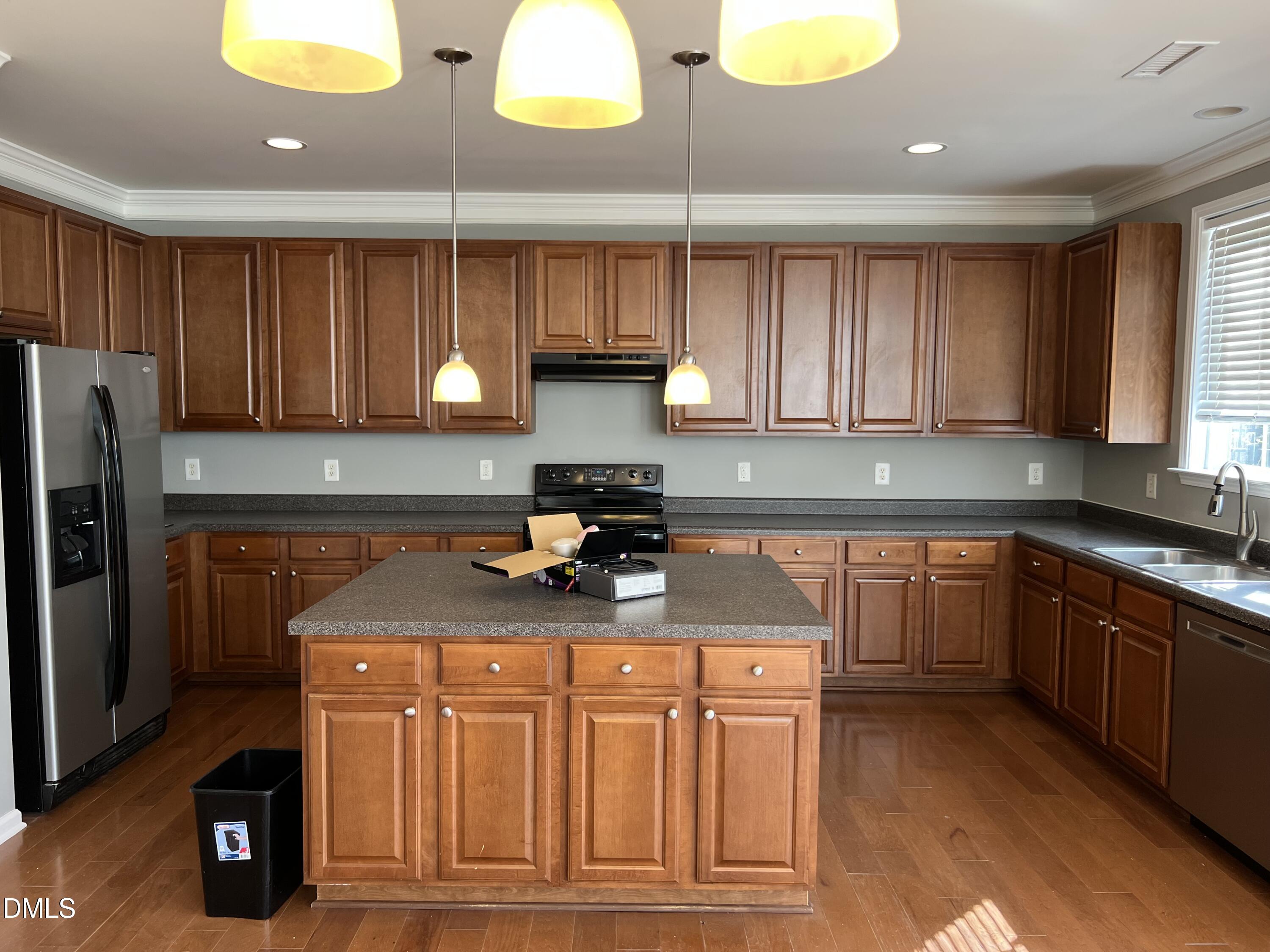 527 Emerald Downs Road Cary, NC 27519 - Photo 3 of 12 a kitchen with stainless steel appliances granite countertop a sink a stove cabinets and a counter space