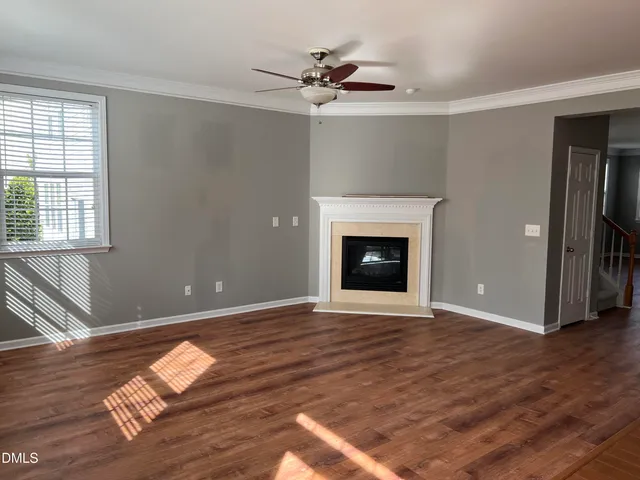 wooden floor fireplace and windows in an empty room