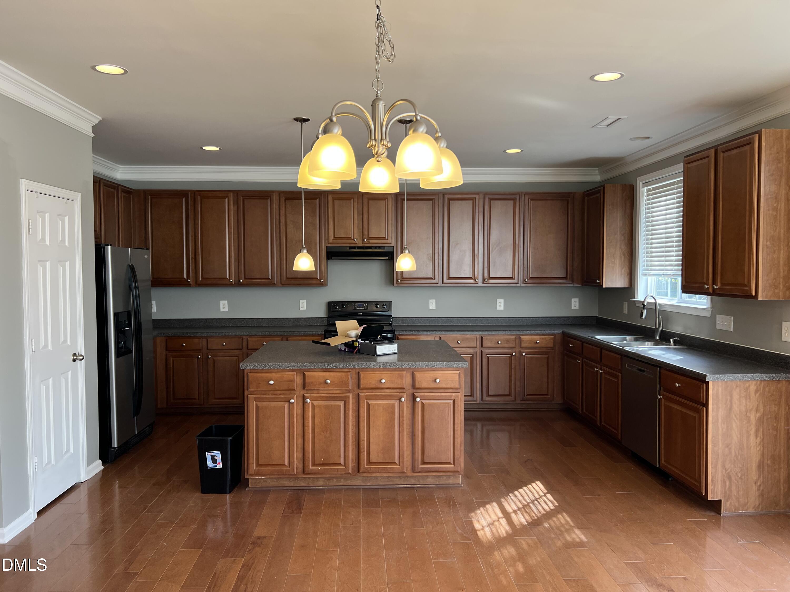 527 Emerald Downs Road Cary, NC 27519 - Photo 6 of 12 a kitchen with stainless steel appliances granite countertop wooden cabinets a stove a sink and a wooden floor
