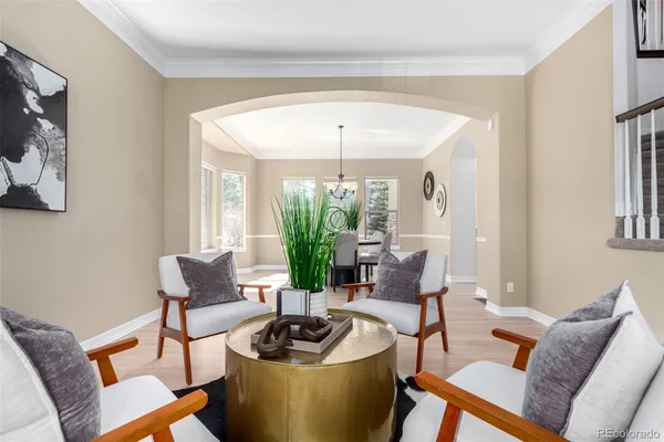a dining room with furniture a chandelier and wooden floor