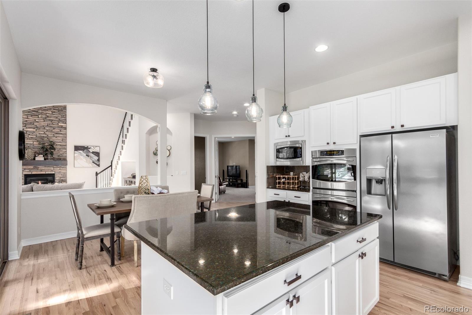 20166 East Shady Ridge Road Parker, CO 80134 - Photo 16 of 50 a kitchen with stainless steel appliances granite countertop a sink a stove and a refrigerator