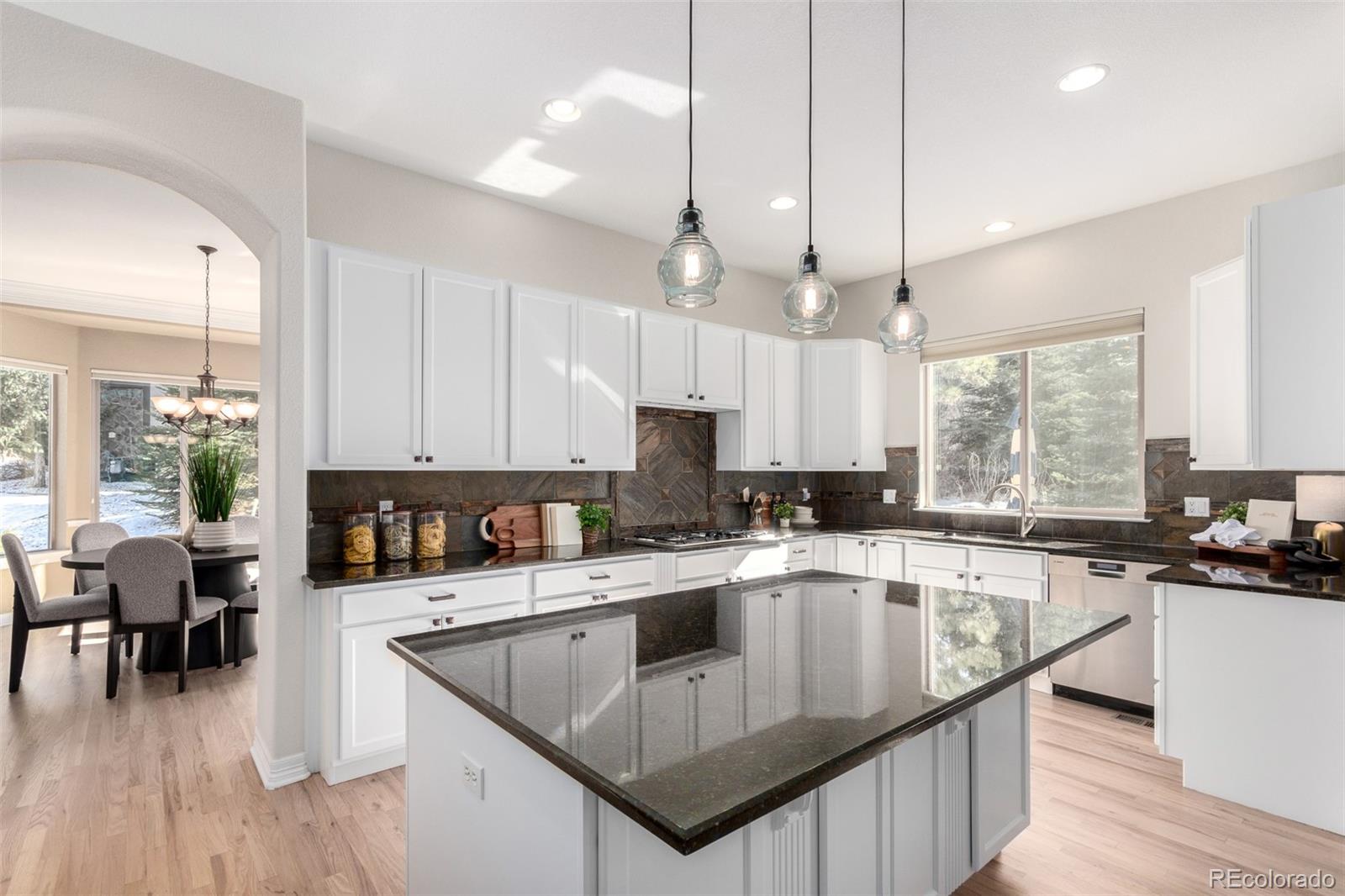 20166 East Shady Ridge Road Parker, CO 80134 - Photo 17 of 50 a kitchen with kitchen island granite countertop a sink a counter top space appliances and cabinets