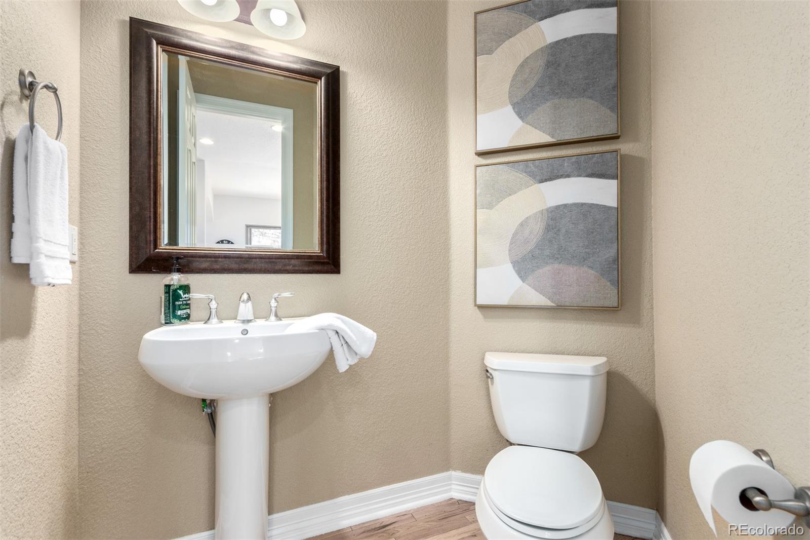 20166 East Shady Ridge Road Parker, CO 80134 - Photo 19 of 50 a bathroom with a toilet sink and mirror