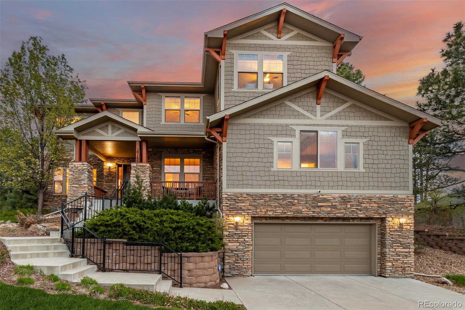 20166 East Shady Ridge Road Parker, CO 80134 - Photo 2 of 50 a front view of a house with garage and plants
