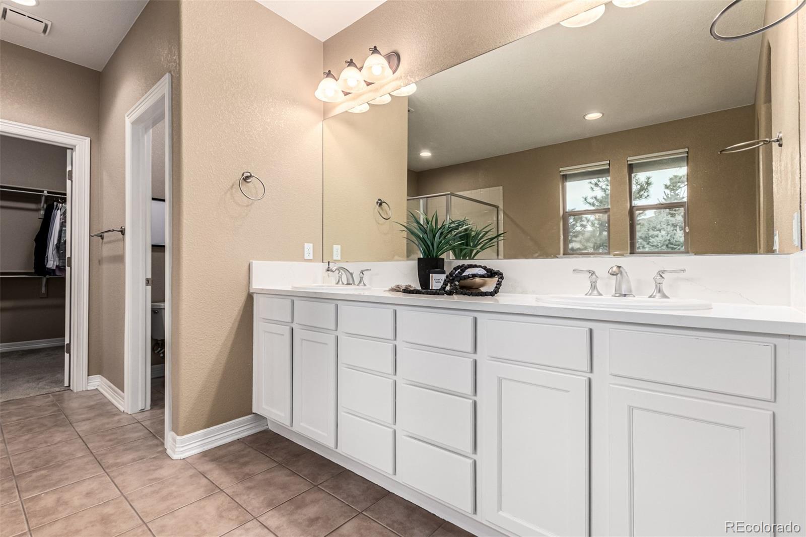 20166 East Shady Ridge Road Parker, CO 80134 - Photo 27 of 50 a spacious bathroom with a double vanity sink and a mirror