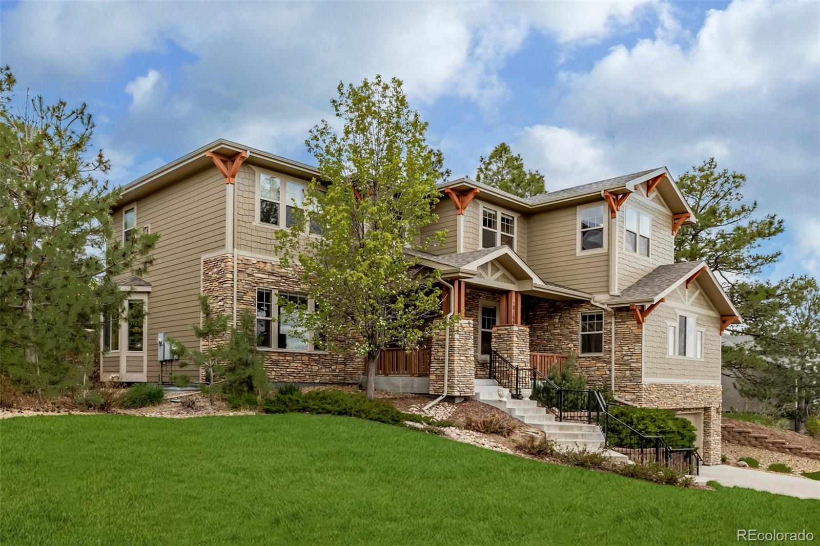 20166 East Shady Ridge Road Parker, CO 80134 - Photo 3 of 50 a front view of a house with a garden and plants