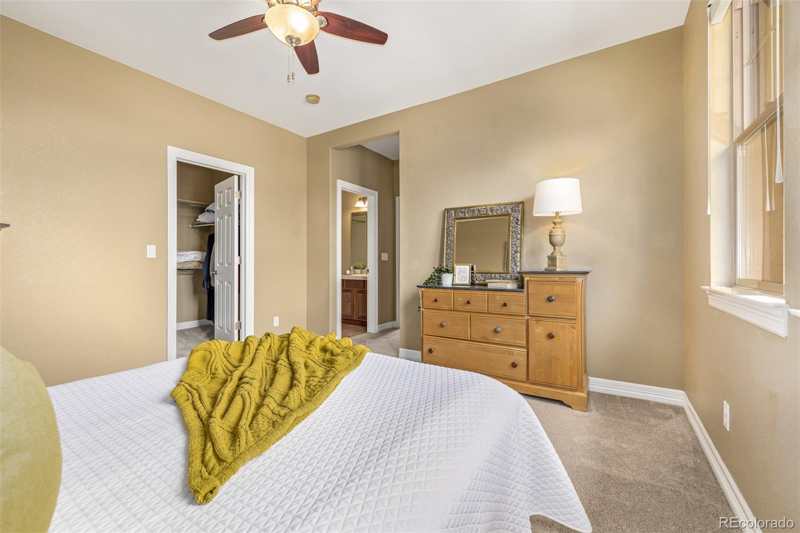 20166 East Shady Ridge Road Parker, CO 80134 - Photo 31 of 50 a bedroom with a bed and a chandelier