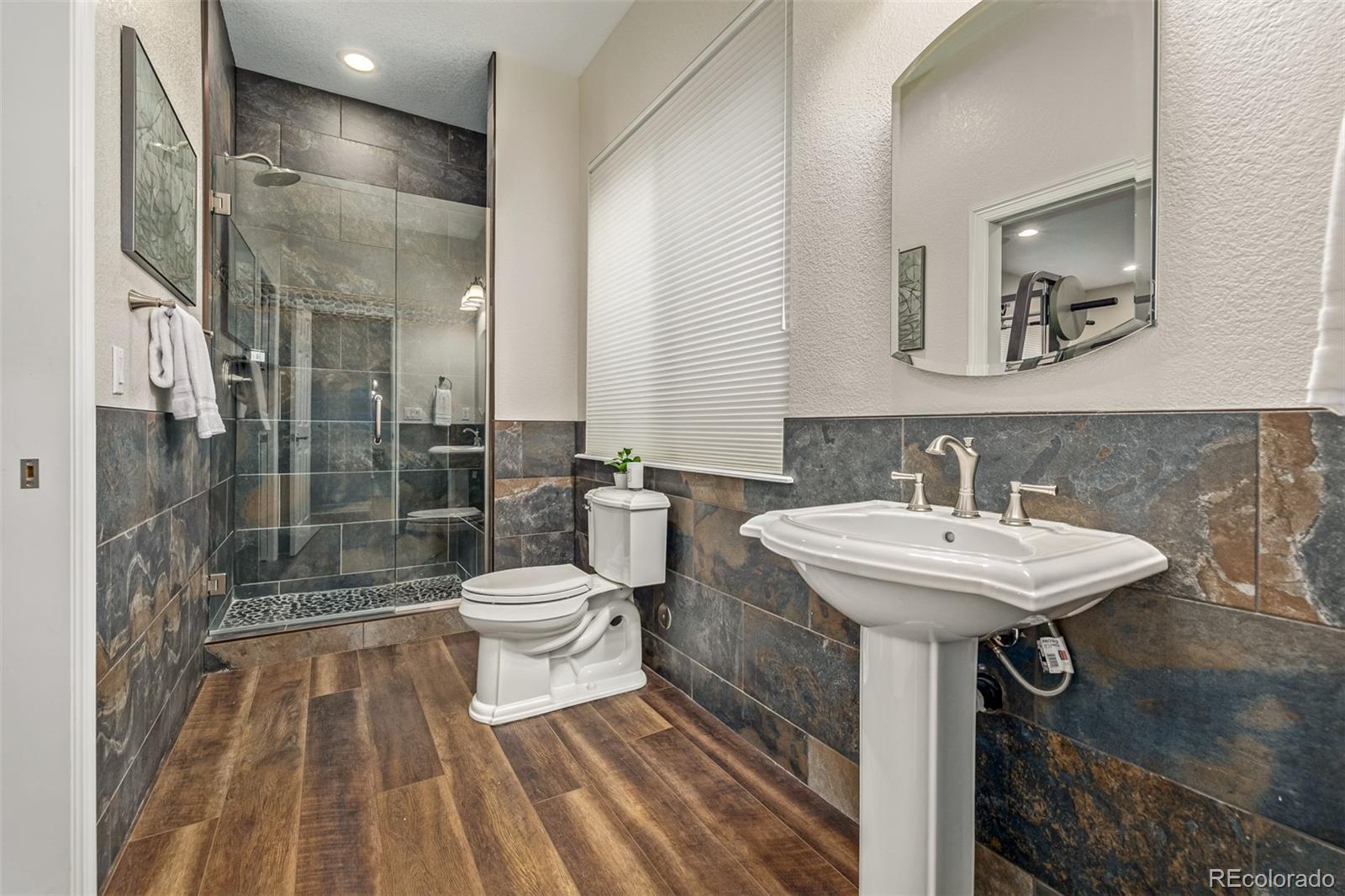 20166 East Shady Ridge Road Parker, CO 80134 - Photo 38 of 50 a bathroom with a sink toilet and shower