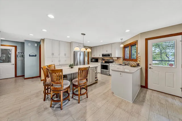 a kitchen with granite countertop white cabinets and white appliances