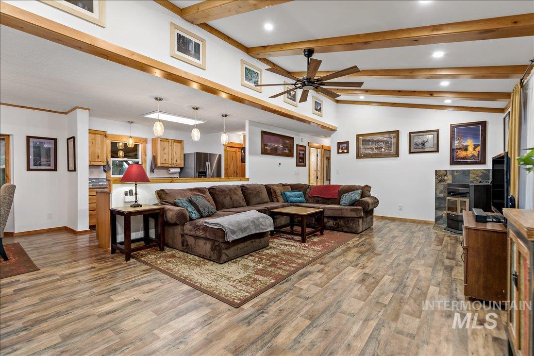 79 Sunset Loop Cascade, ID 83611 - Photo 7 of 44 Spacious living area featuring wood-finish flooring, exposed wood ceiling beams, and a ceiling fan