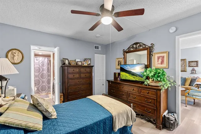 a bedroom with a bed a dresser and a chandelier