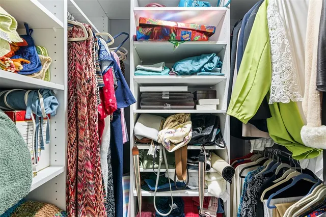a view of walk in closet with clothes and shoes