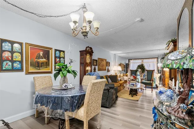 a view of a dining room with furniture a chandelier and wooden floor