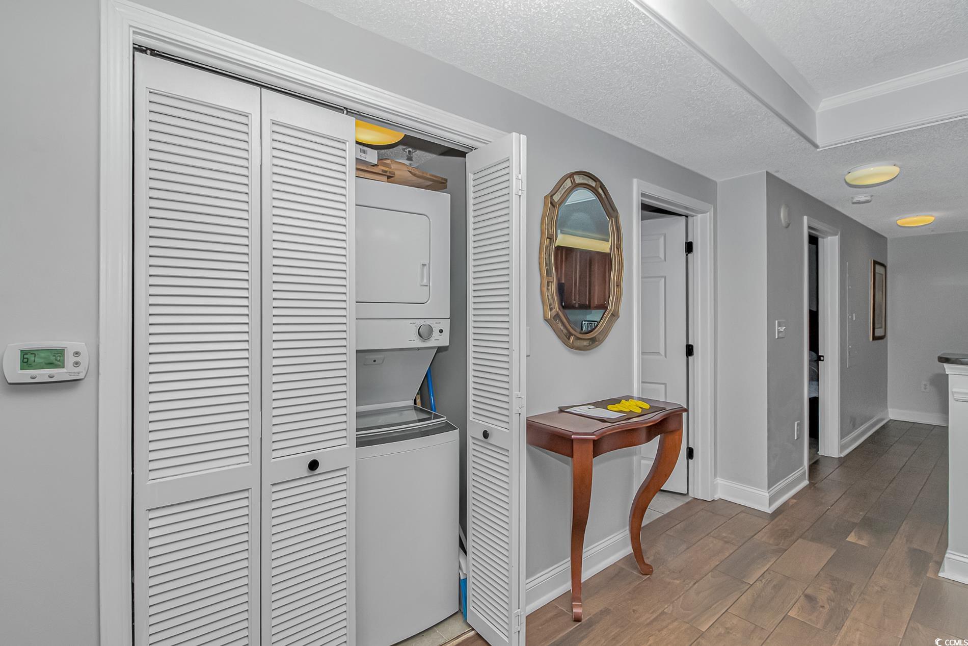 2600 North Ocean Boulevard, Unit 1715 Myrtle Beach, SC 29577 - Photo 5 of 34 Washroom with a textured ceiling, wood finished floors, and stacked washer / drying machine