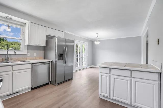 a kitchen with white cabinets and appliances