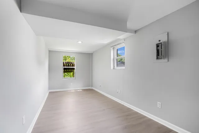 an empty room with windows and cabinet