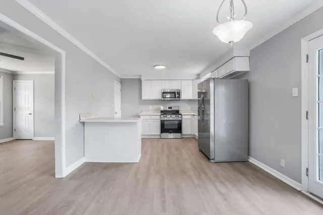 a kitchen with a refrigerator and a stove top oven