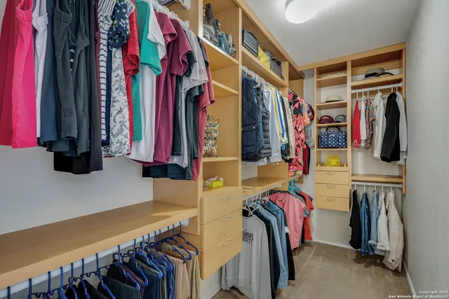 a view of walk in closet with clothes and shoes