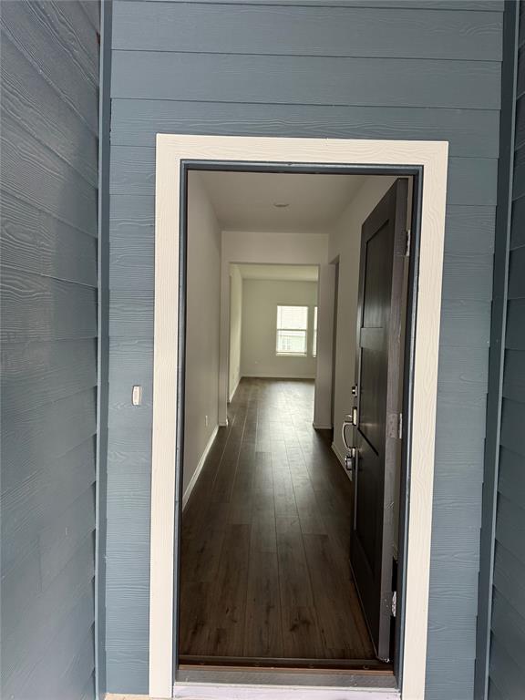 216 Jeffers Kyle, TX 78640 - Photo 5 of 19 Entryway featuring wood-finish flooring, a dark paneled door with brushed nickel hardware, and light-colored walls