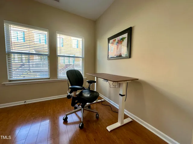 a view of a workspace with furniture and a window