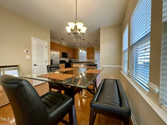 a view of a dining room with furniture a chandelier and wooden floor