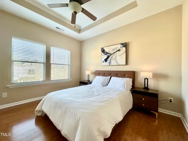 a bedroom with a bed and wooden floor