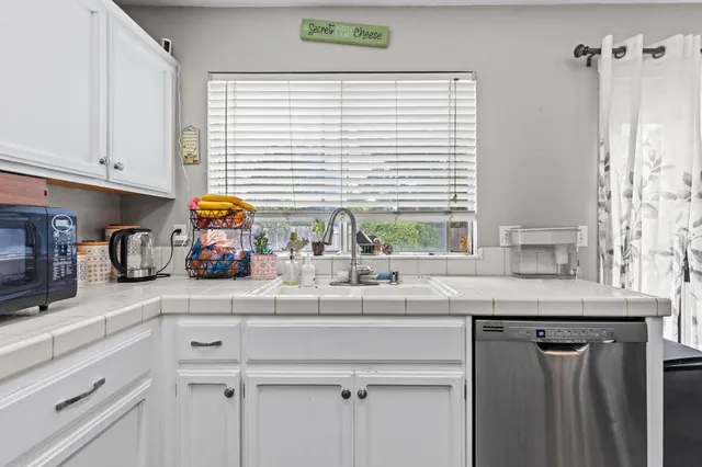 a kitchen with cabinets stainless steel appliances and wooden floor