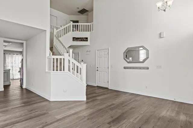 a view of empty room with wooden floor and entryway