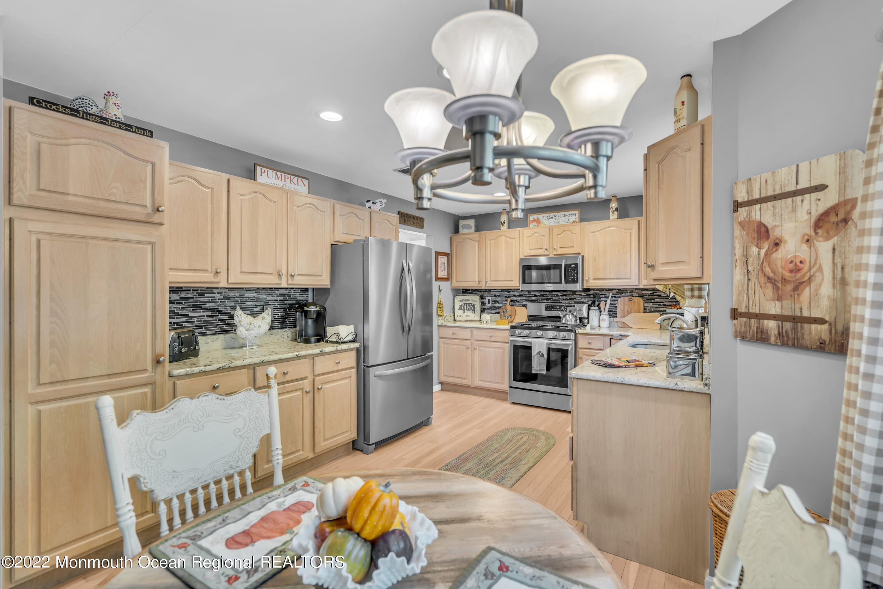 124 Compass Road Manahawkin, NJ 08050 - Photo 12 of 36 a kitchen with stainless steel appliances a refrigerator a stove a sink dishwasher a dining table and chairs with wooden floor