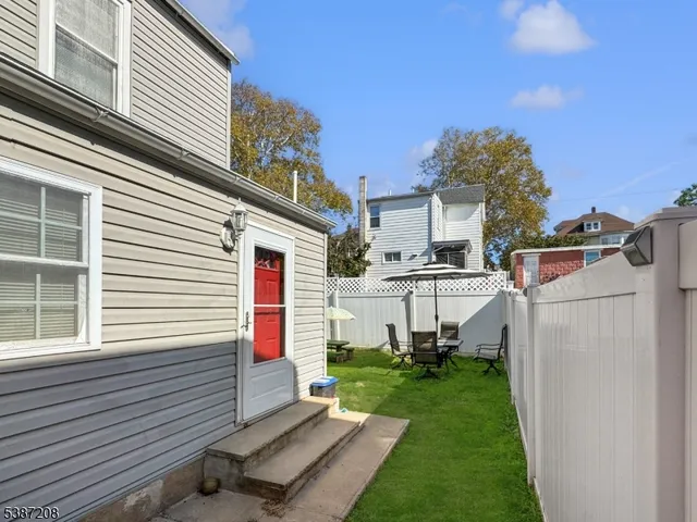 a view of a house with backyard and a tree