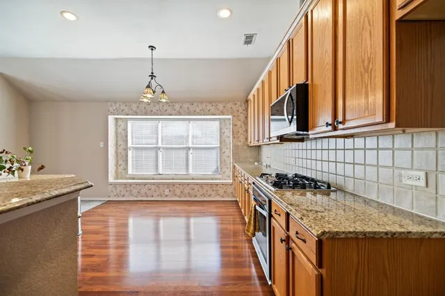 a kitchen with a stove a sink and a wooden cabinets