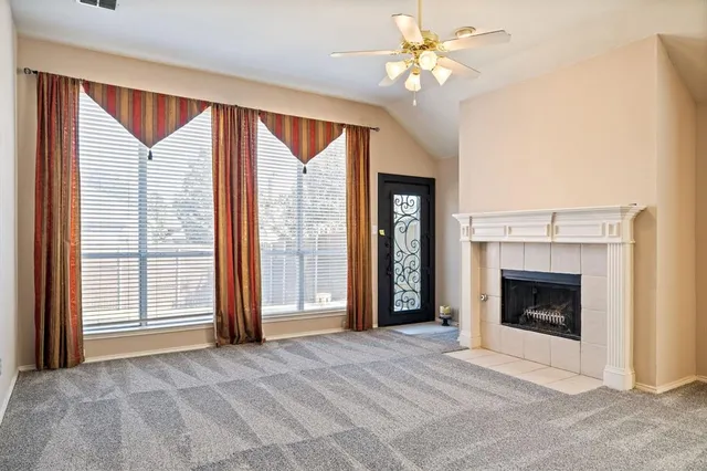 a view of an empty room with a fireplace and a window
