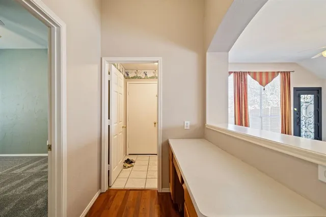 a view of an empty room with window and chandelier fan