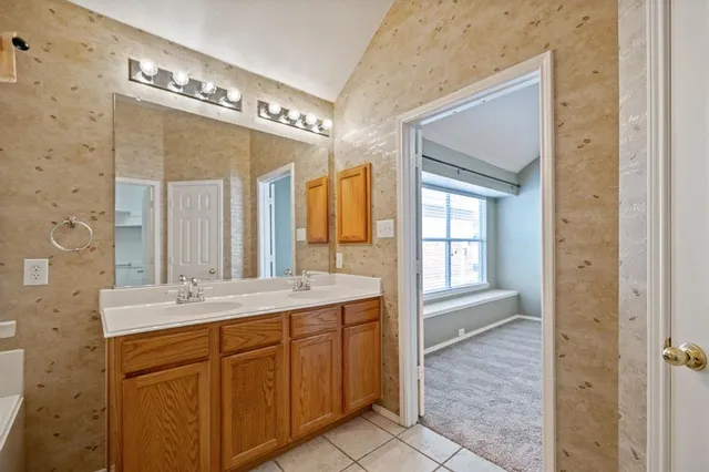 a spacious bathroom with a double vanity sink a large mirror and a shower