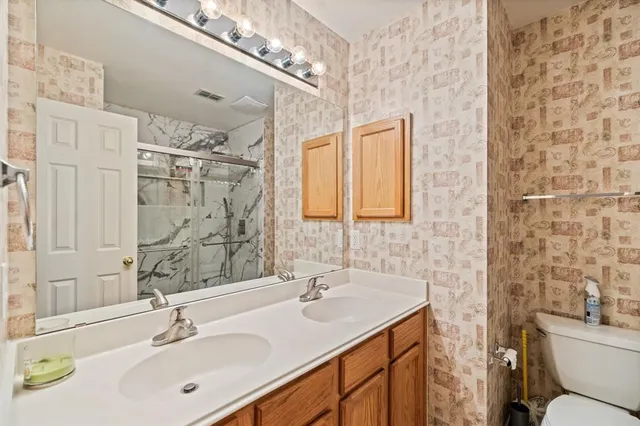 a bathroom with a sink double vanity and a toilet