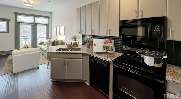 a kitchen that has a lot of cabinets a sink and wooden floor