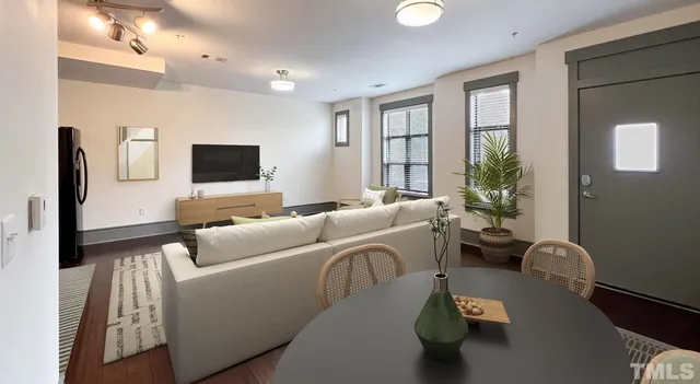 a kitchen with stainless steel appliances granite countertop a refrigerator a stove and a dining table with wooden floor