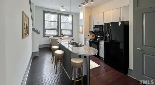 a kitchen with stainless steel appliances granite countertop a refrigerator and a sink