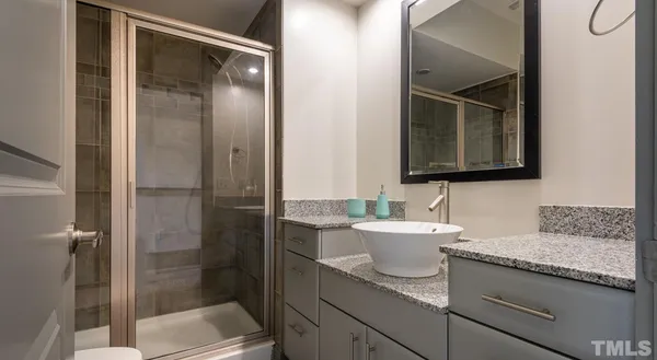 a bathroom with a granite countertop sink and a toilet