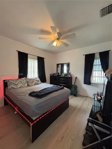 a bedroom with a bed and a flat tv screen on dresser