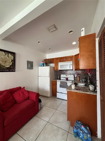 a living room with furniture and kitchen view