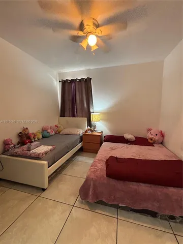 a bedroom with a bed and a chandelier fan