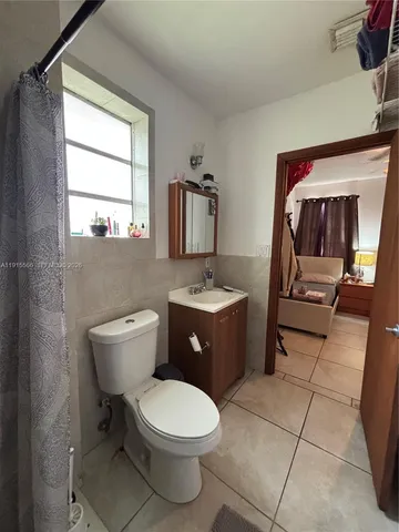 a bathroom with a toilet a sink a mirror and vanity