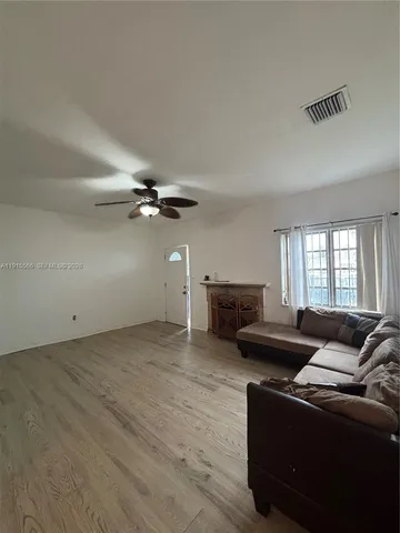 a living room with furniture and a ceiling fan
