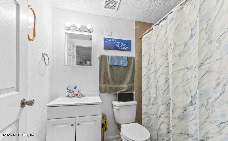 3131 Dignan Street Jacksonville, FL 32254 - Photo 12 of 16 a bathroom with a toilet sink and mirror