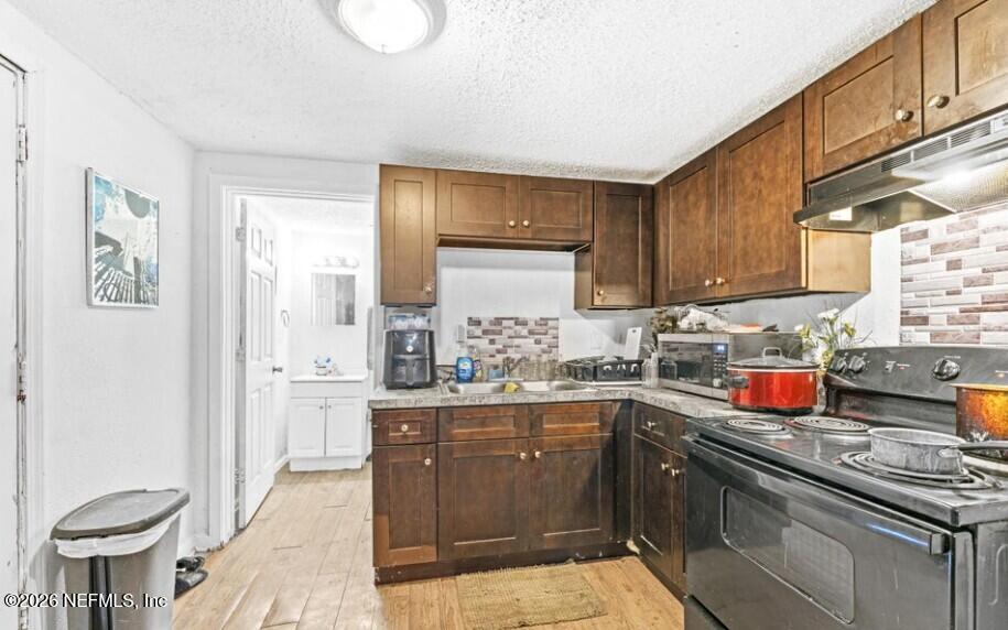 3131 Dignan Street Jacksonville, FL 32254 - Photo 8 of 16 a kitchen with stainless steel appliances granite countertop a stove a sink dishwasher and cabinets with wooden floor