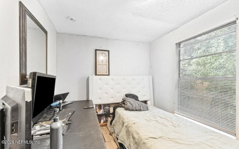 3131 Dignan Street Jacksonville, FL 32254 - Photo 10 of 16 a bedroom with a bed a computer on the desk and a wooden floor