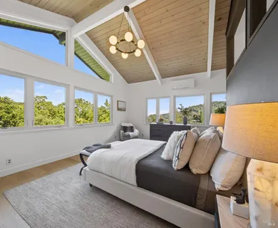 a bedroom with a bed and a large window