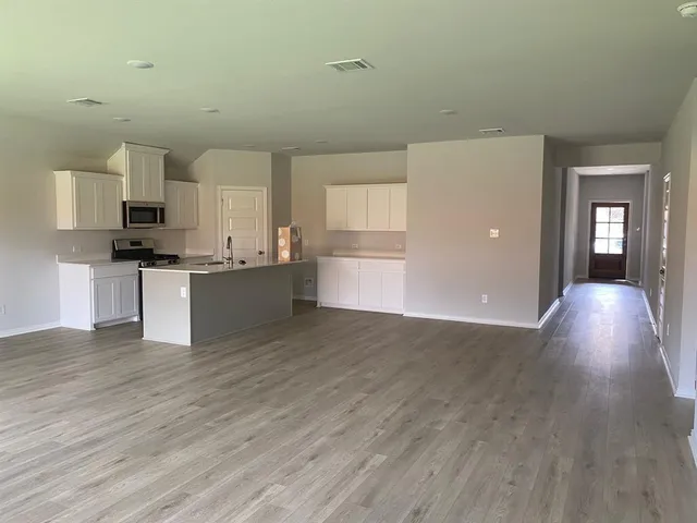 a view of a kitchen with a sink microwave and cabinets